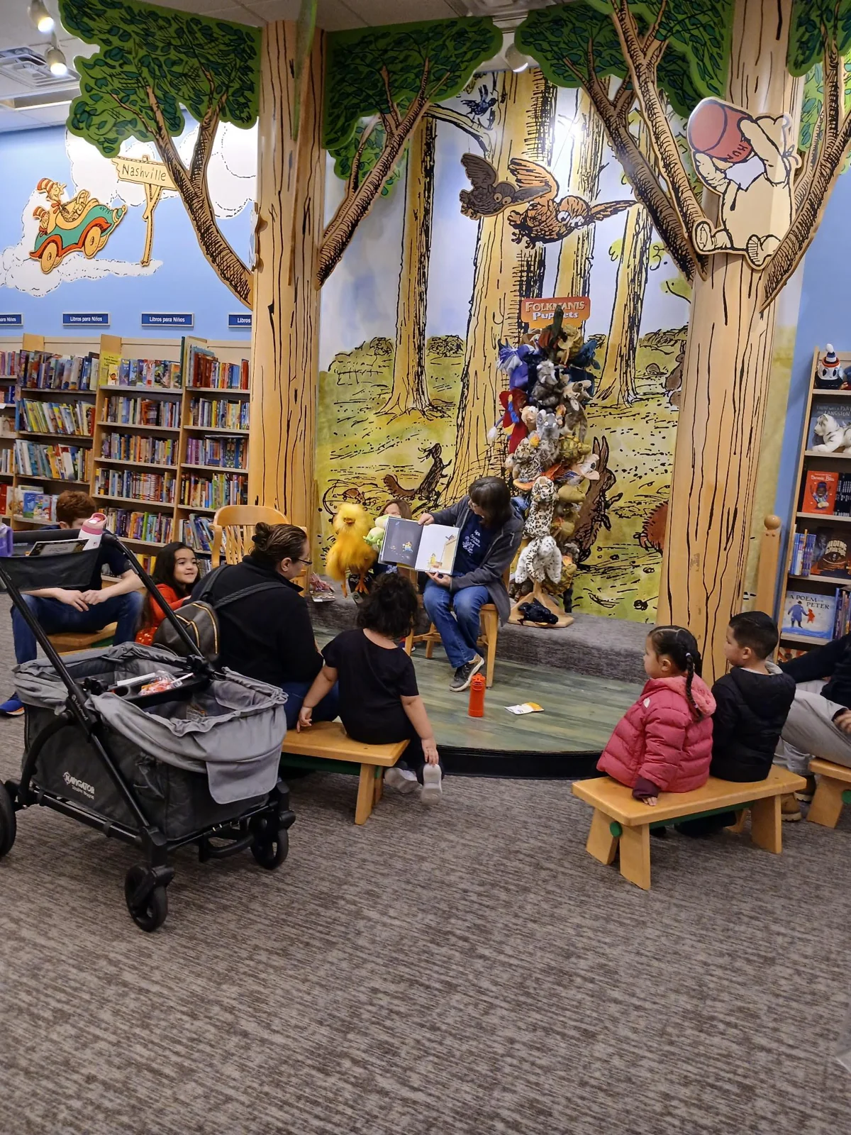 A group gathered beneath a library’s indoor tree